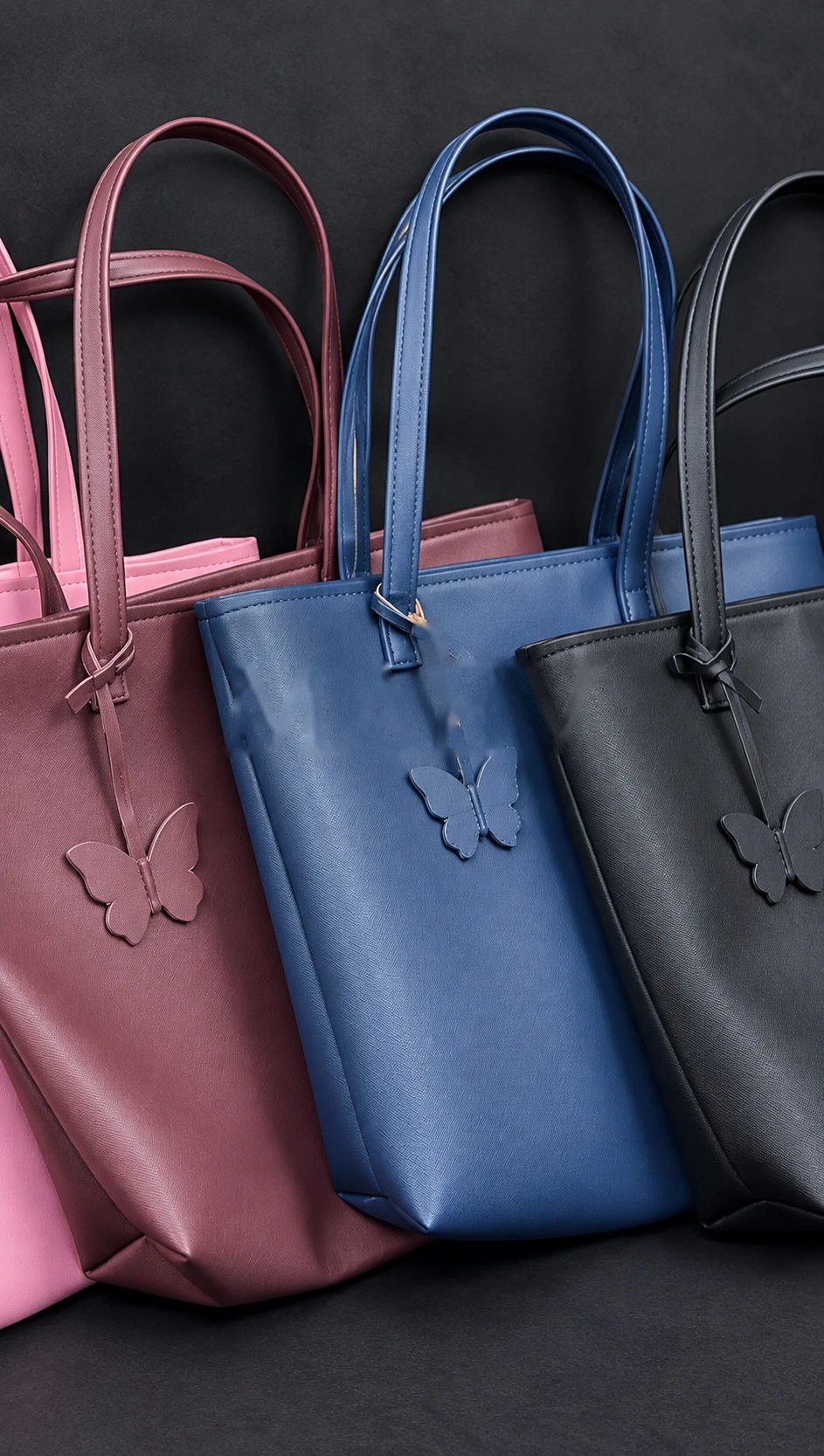 Wine, blue and black MAEV leather totes, each with a leather butterfly charm